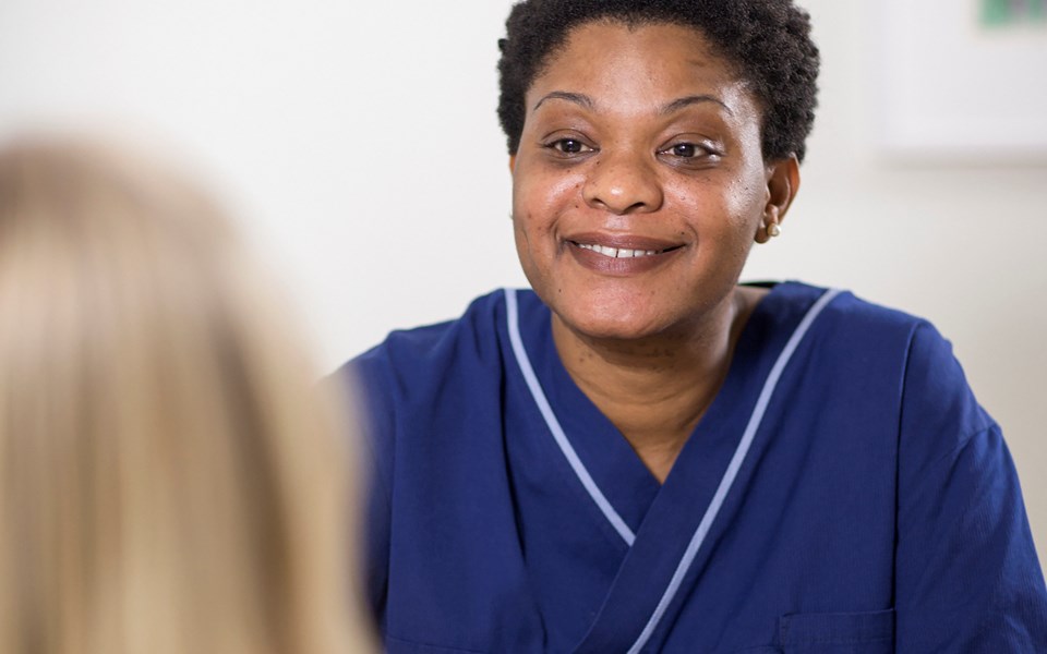 En undersköterska pratar med en patient